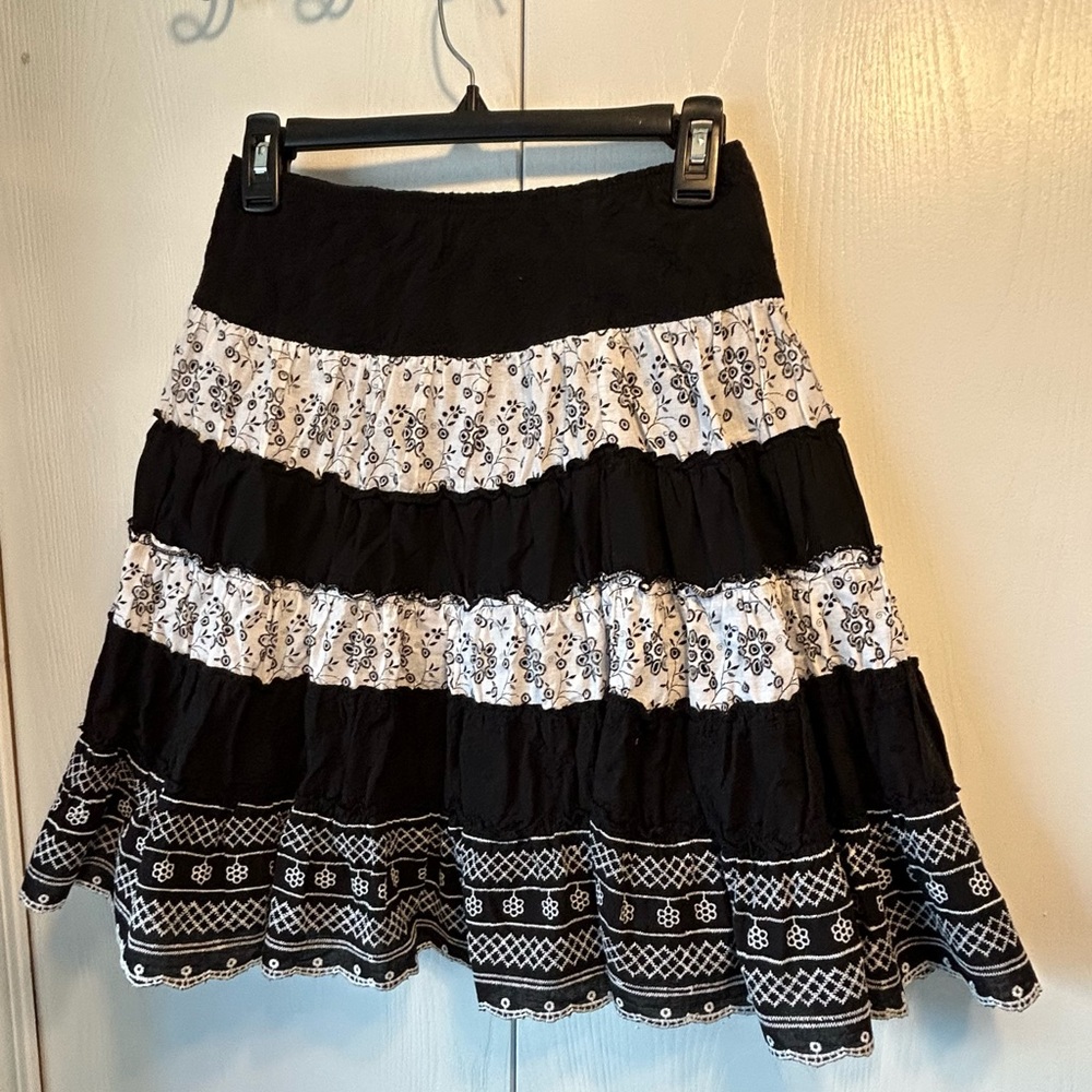 Young trendy black and white striped skirt with variety of different materials.